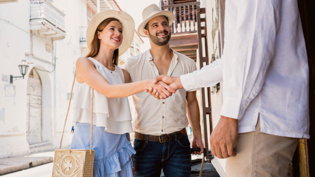 Couple shaking hands with host, arriving at Airbnb.